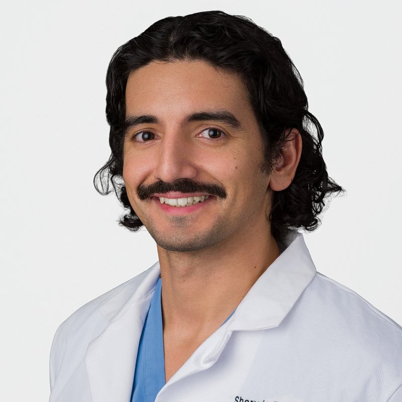 Professional LinkedIn headshot of a pediatrician from SUNY Downstate Brooklyn, with soft light and a white backdrop.
