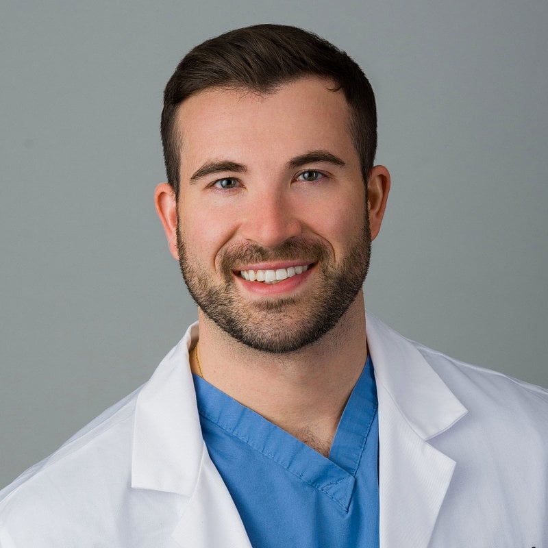 Professional studio portrait of a Brooklyn physician from Kings County Hospital, captured against a light gray backdrop.