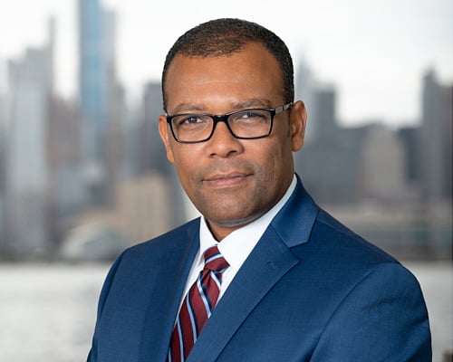 Professional LinkedIn headshot in NYC with East River skyline in the background